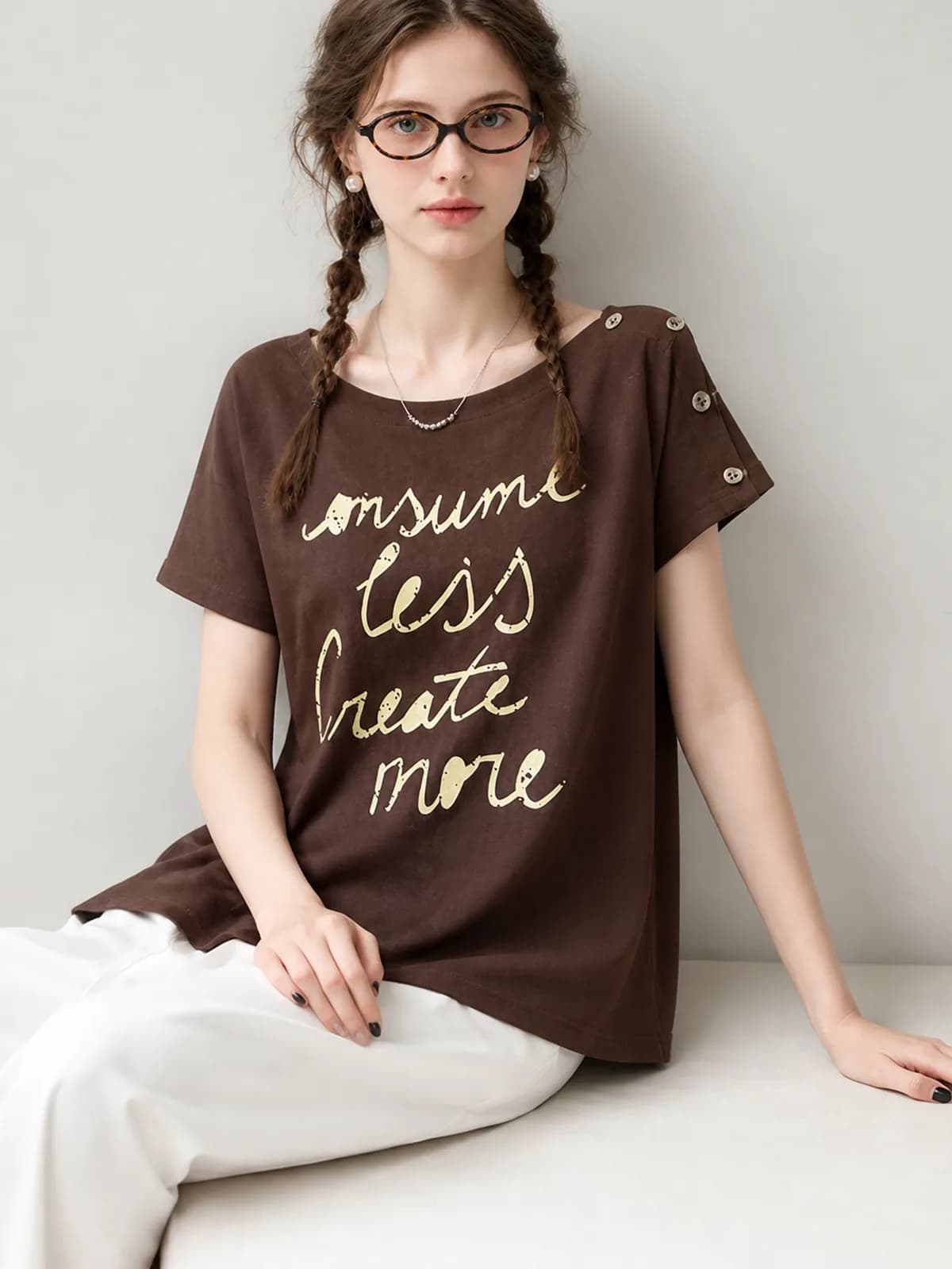 AI clothing photo of a brown slogan tee with a buttoned shoulder tab