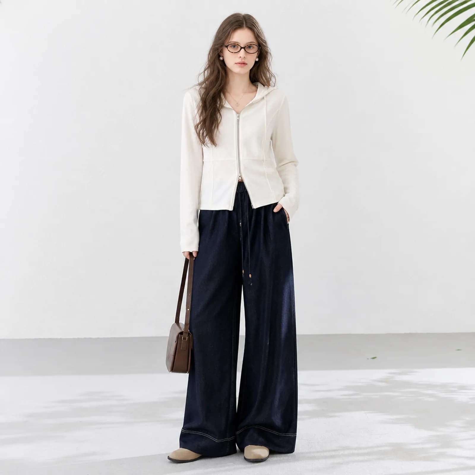 AI clothing photo of a cream fitted zip hoodie with indigo wide-leg jeans