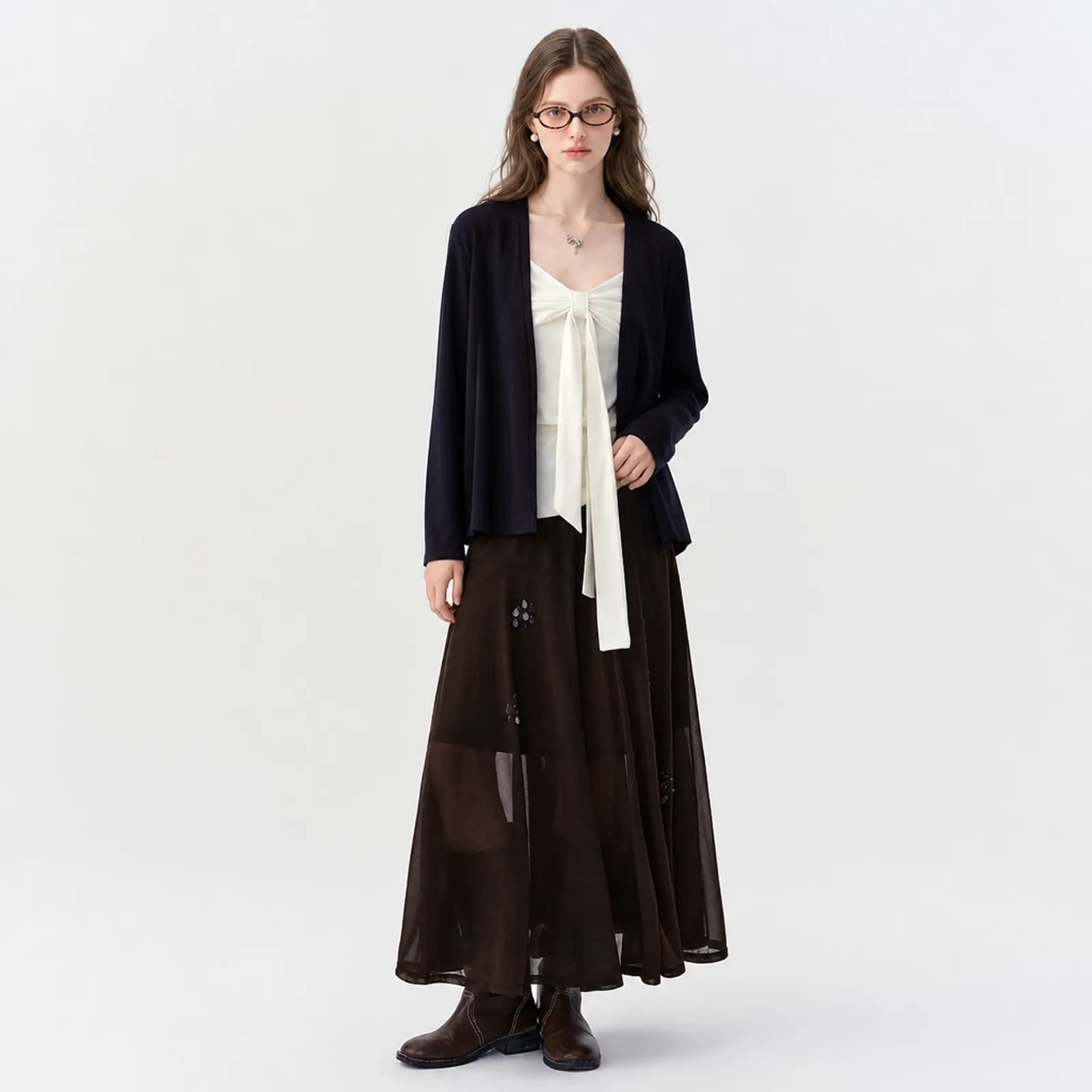 AI clothing photo of a navy cardigan, cream tie cami and brown sheer maxi skirt