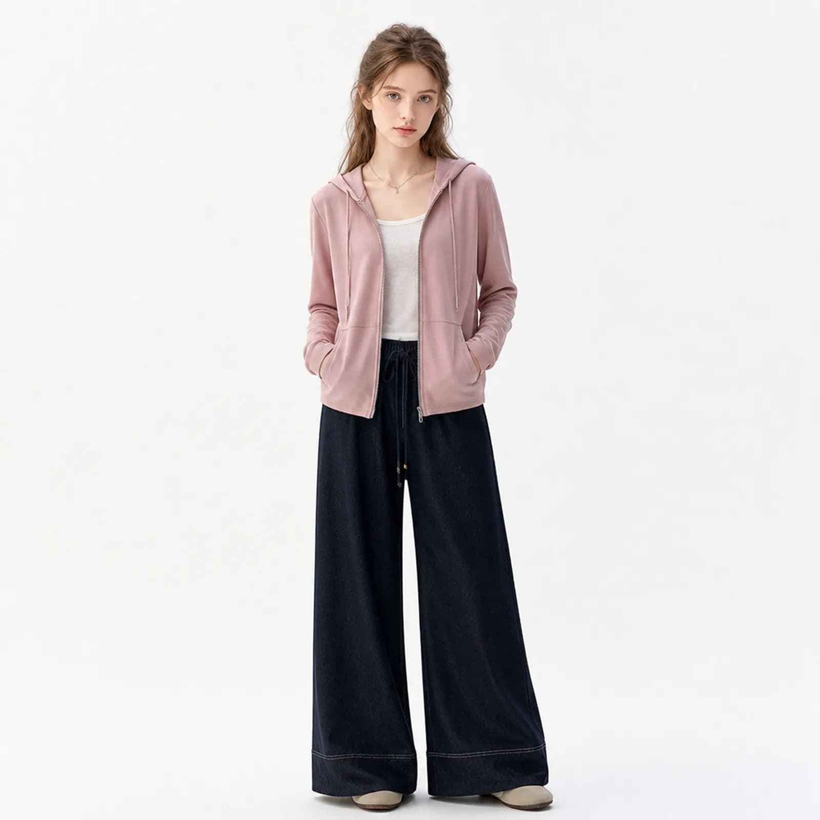 AI model in a dusty pink zip hoodie and dark indigo wide-leg trousers