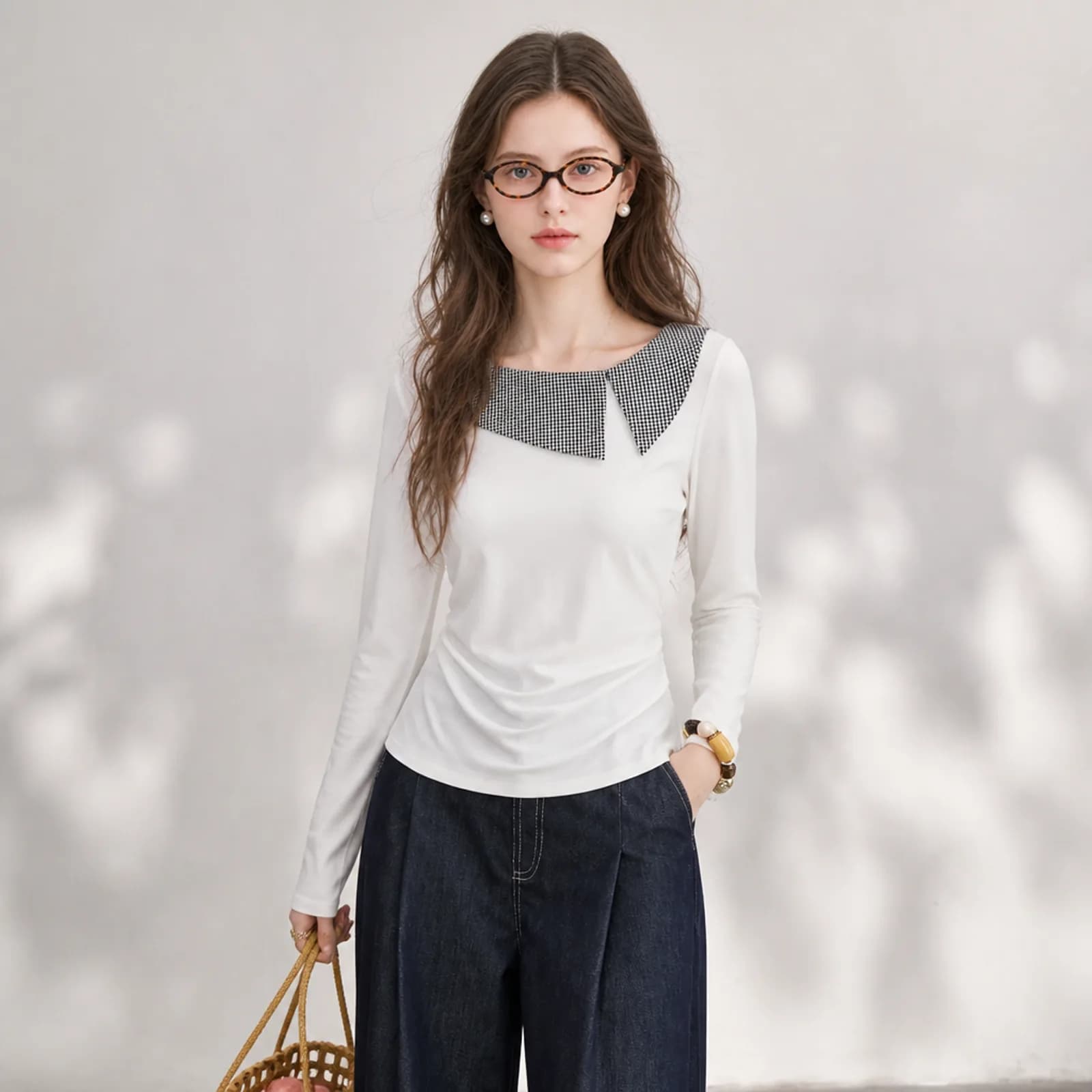 AI model in a white top with an asymmetric gingham collar and indigo jeans