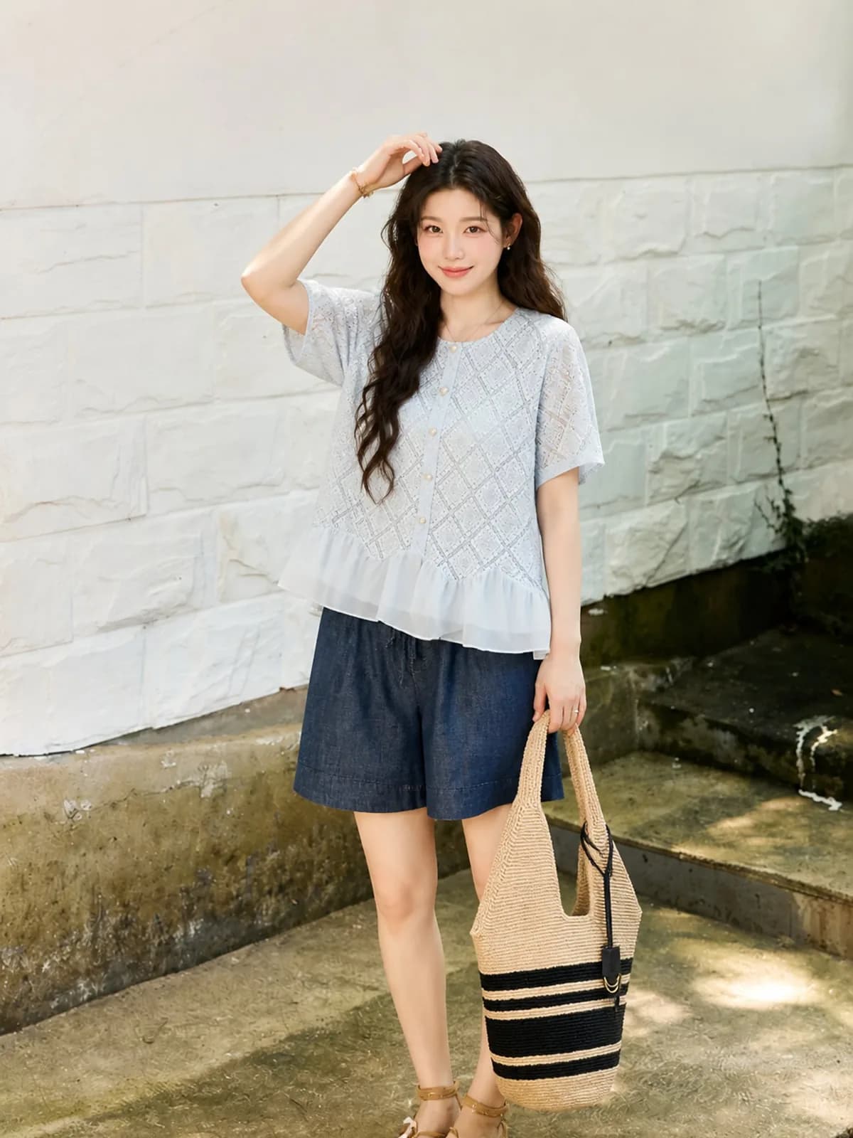Pale blue eyelet top with a chiffon ruffle hem against a painted brick wall