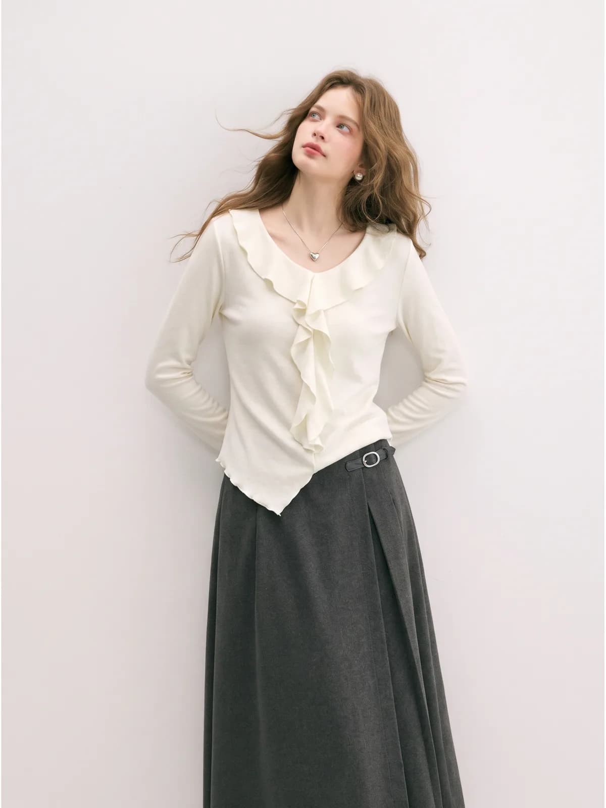 AI model wearing a cream ruffle-placket top with a lettuce hem and a charcoal maxi skirt