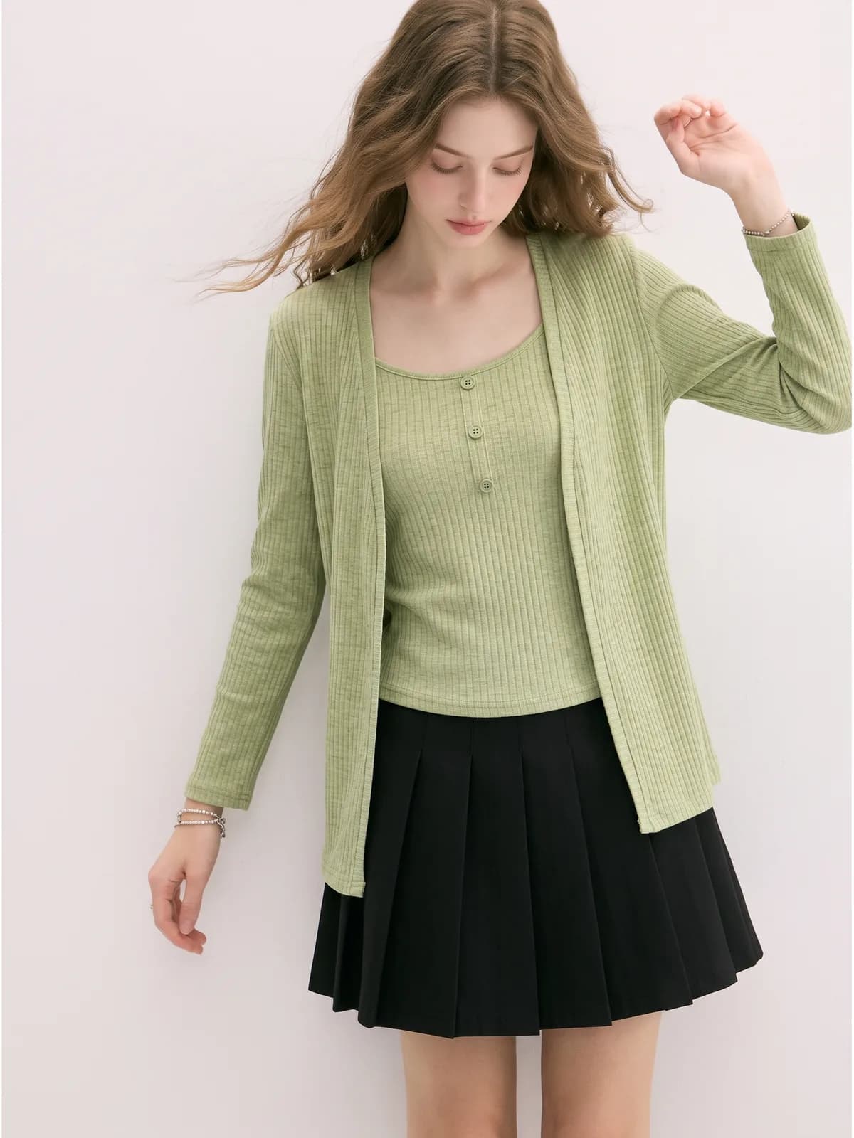 Close crop of a sage green ribbed cardigan over a matching cami on an AI model