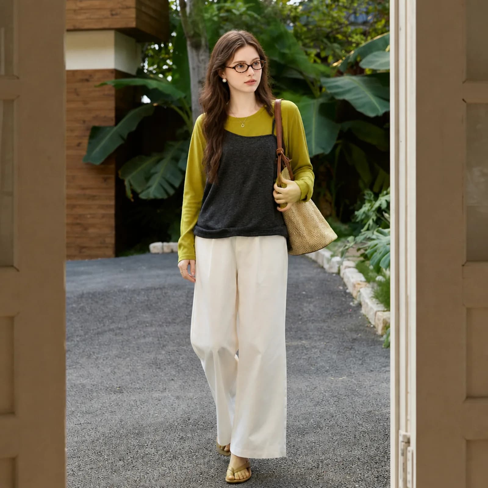 Charcoal cami over a chartreuse top on an AI model walking in a garden setting