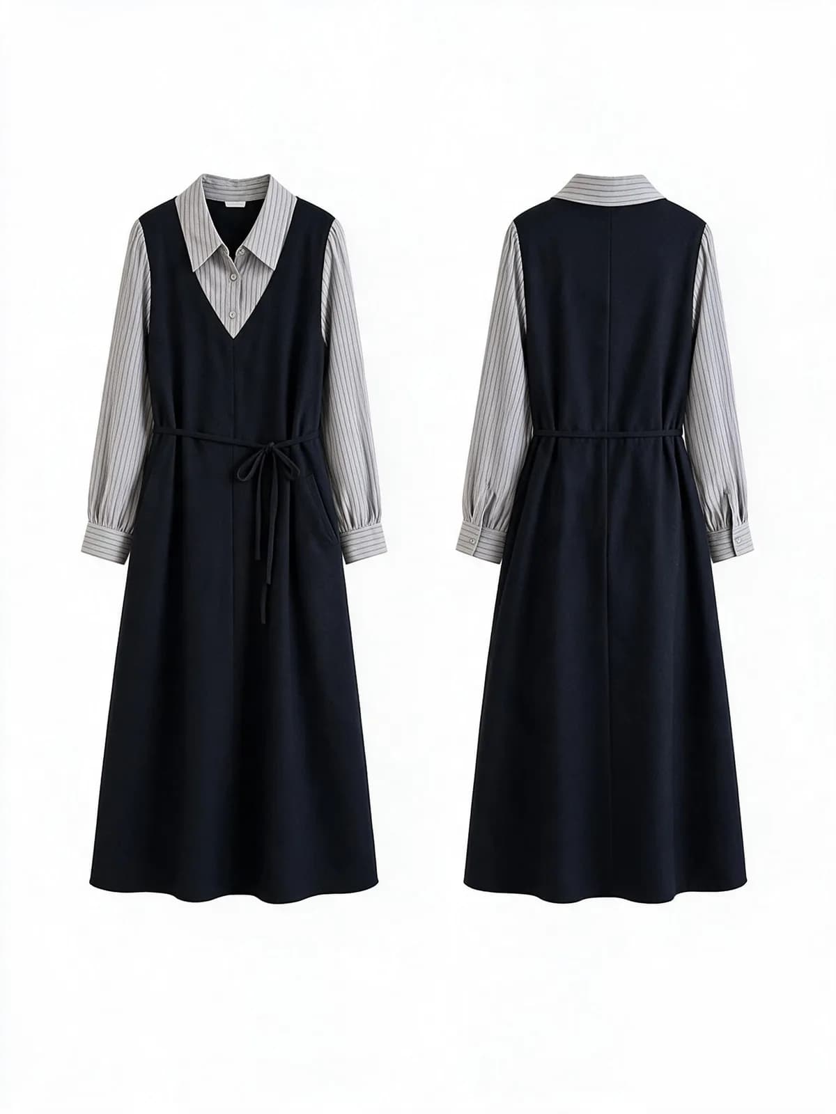 White background photo of a navy pinafore dress over a grey striped shirt